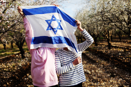 Two teenage girls are holding an Israeli flag outdoorsの写真素材