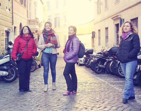 Women best friends smiling and walking at the city.  Outdoors lifestyle fashion portrait. Positive emotions.の写真素材