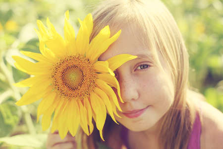 Portrait of cute girl enjoying of freedom in the sunflowers fieldの写真素材