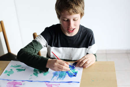 Cute 12 years old autistic boy drawingの写真素材