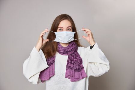 Girl in medical mask on white background empty spaceの写真素材