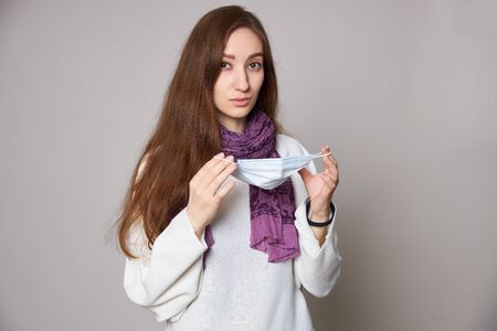 Girl in medical mask on white background empty spaceの写真素材