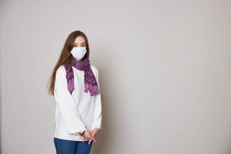 Girl in medical mask on white background empty spaceの写真素材