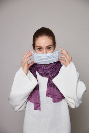 Girl in medical mask on white background empty spaceの写真素材