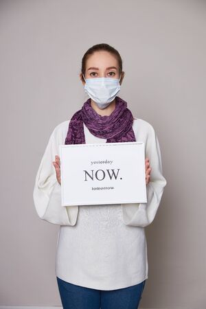 Girl in medical mask on white background empty spaceの写真素材