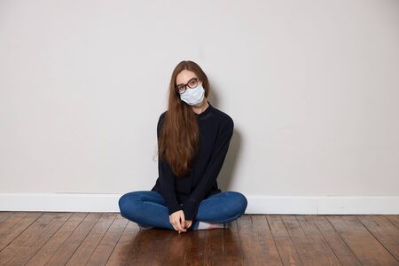 Girl in medical mask on white background empty spaceの写真素材