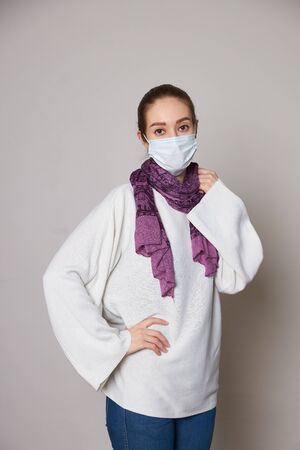 Girl in medical mask on white background empty spaceの写真素材