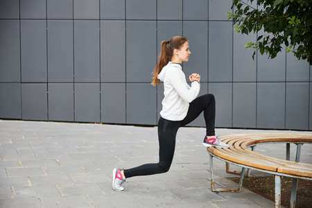 A young girl trains on the street. Grey metal background. Cityscape. Empty space for your text.の写真素材