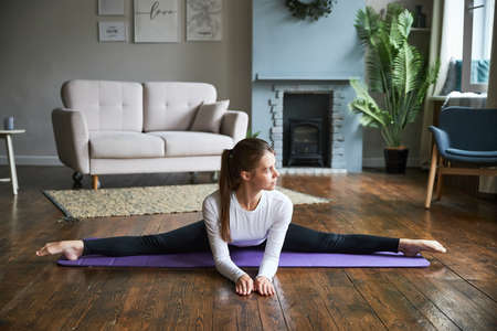 Young woman exercising at home in a living room.の写真素材