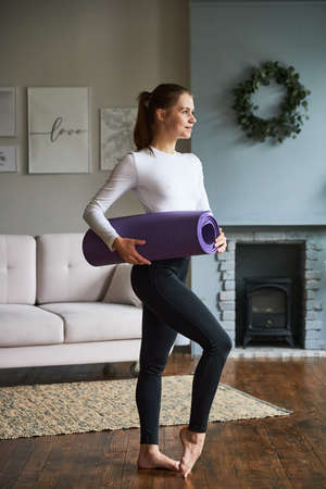 Young woman exercising at home in a living room.の写真素材