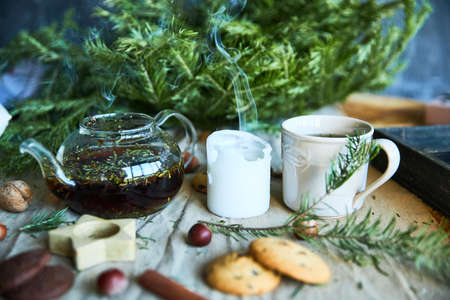 Gingerbread cookies, fruit tea and fir tree branches on a wooden black background. Christmas and New Year treat.の写真素材