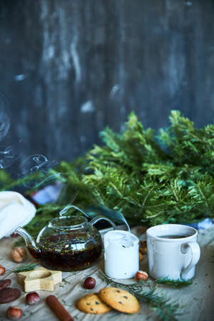 Gingerbread cookies, fruit tea and fir tree branches on a wooden black background. Christmas and New Year treat.の写真素材
