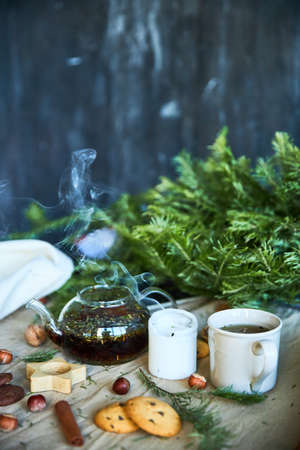 Gingerbread cookies, fruit tea and fir tree branches on a wooden black background. Christmas and New Year treat.の写真素材