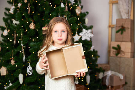 Girl shows empty Christmas present, girl upset and looks into cameraの写真素材