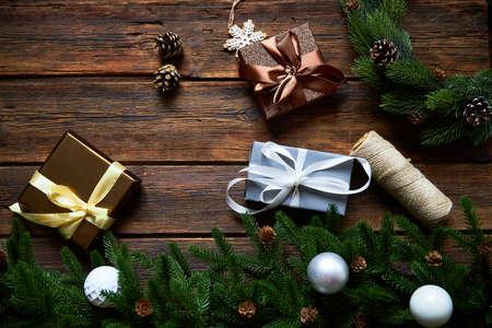 Preparing for Christmas or New Year holiday. Flat-lay of fur tree branches, evergreen wreaths, christmas wraped gift, wooden table background, top view, copy spaceの写真素材