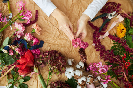 Flat lay composition florist creates a bouquet on craft paperの写真素材