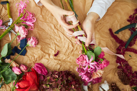 Flat lay composition florist creates a bouquet on craft paperの写真素材