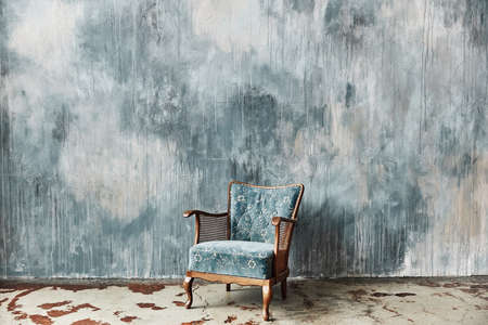 Beautiful blue old vintage chair against the background of a textured wallの写真素材
