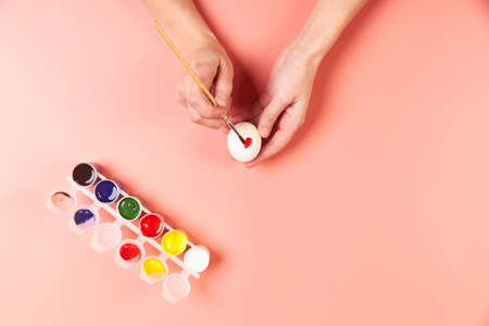 A girl paints eggs red for Easterの写真素材