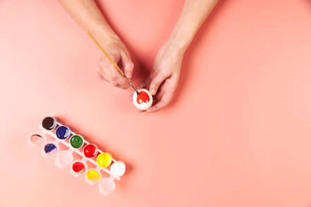 A girl paints eggs red for Easterの写真素材