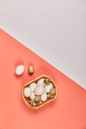 Eggs for Easter in a basket pink white backgroundの写真素材