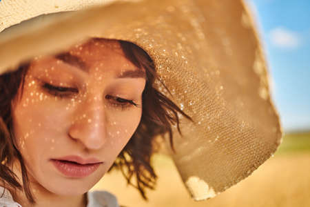A close portrait of a woman in a summer hatの写真素材