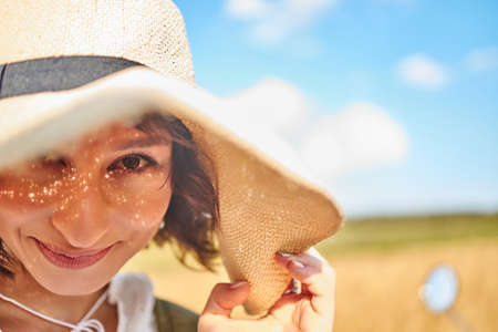 A close portrait of a woman in a summer hatの写真素材