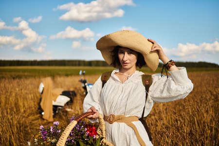 A woman holds a basket with summer wildflowersの写真素材