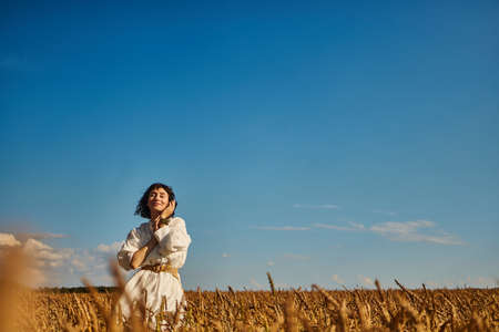 woman on the background of a field of rye summer freedom sky