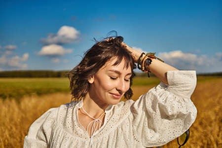 woman on the background of a field of rye summer freedom skyの写真素材