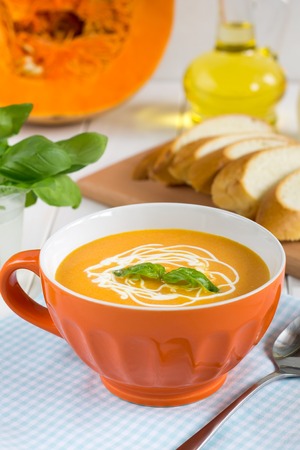Pumpkin soup with cream on a white table. The autumn seasonal dish of vegetables.の写真素材