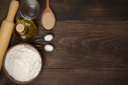 Dark rural background with ingredients for pizza dough. Top view, copy space.の写真素材