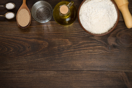 Baking utensils and ingredients for pizza dough on wooden background. Top view, copy space.の写真素材