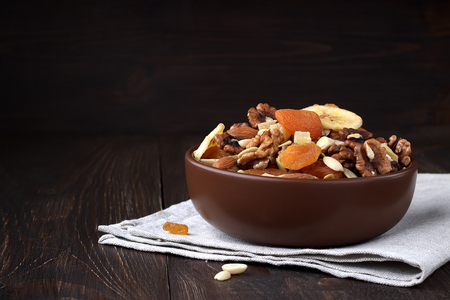 Tasty dried fruits and nuts on wooden table. Nutritious snack in a bowl.の写真素材