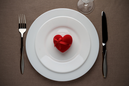 Red heart on the white plate for Valentines day. Top view. Romantic gift with love.の写真素材