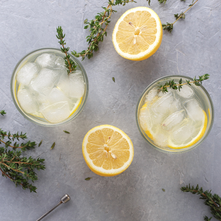 Cold lemonade with thyme in two glasses on the gray stone background, top view.の写真素材