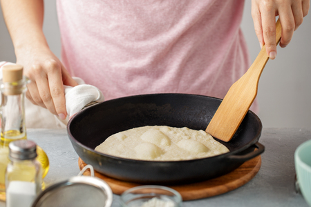Woman frying mexican flatbread on cast iron pan.の写真素材