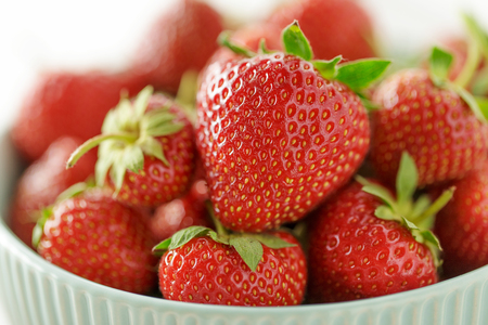 Fresh juicy strawberry in ceramic bowl close-up. Summer ripe berries for healthy diet.の写真素材