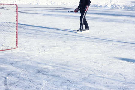 ice hockey player in action kicking with stickの写真素材