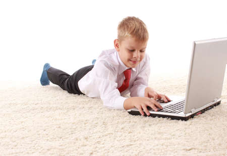 Young handsome man lies on a white background with a white laptopの写真素材