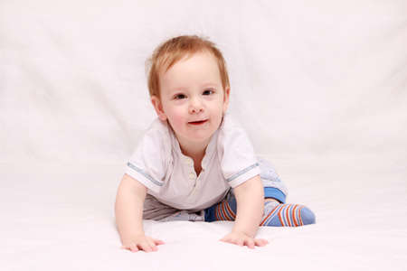 Portrait of a beautiful 6 months baby smiling, crawling on the bed.