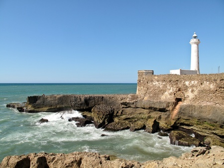 White lighthouse on the cliff with fortifications in Rabat in Moroccoの写真素材