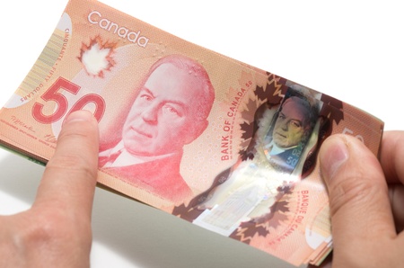 Finger pointing the 50 Canadian dollars 