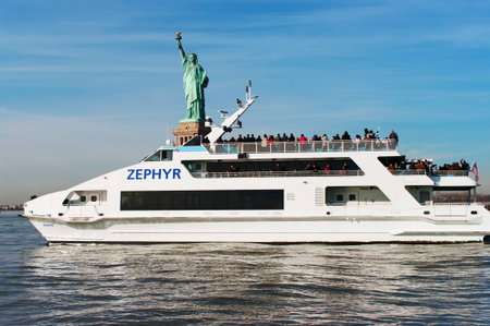 NEW YORK - NOVEMBER 25: Luxury yacht Zephyr filled with tourist  in front of Statue of Liberty on November 25, 2011. Zephyr departs from South Street Seaport for Statue of Liberty Express tours. のeditorial素材