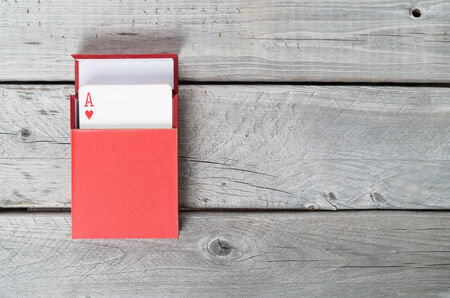 Playing cards in a red box on wooden backgroundの写真素材