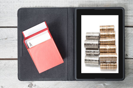 Online gambling concept with a tablet, red box of cards and  moneyの写真素材