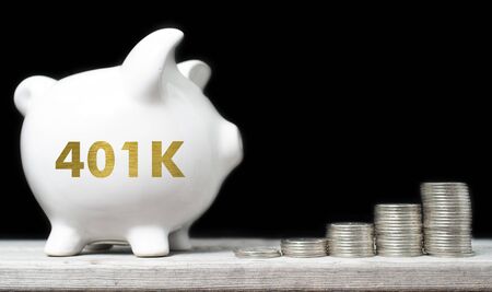 American retirement savings concept with piggy bank and coins against black backgroundの写真素材