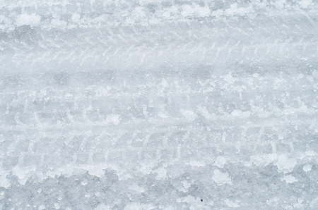Close up of tire tracks on icy roadの写真素材