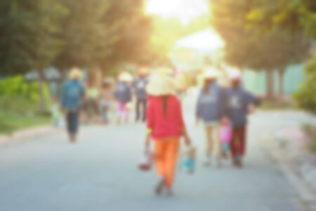 Unidentified Asian workers walking towards the factory.  High key blurred image with flare, bleached effect appliedの写真素材