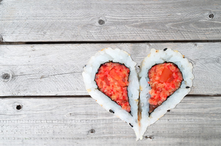 Two pieces of sushi forming the heart shape on a gray wooden backgroundの写真素材